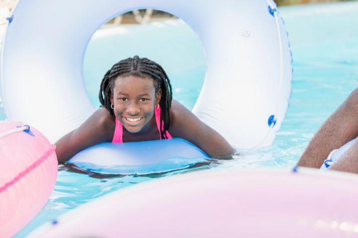 a young child who is in a lazy river with a tube and several tubes around the child